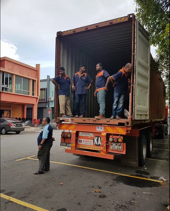 Crew standing inside a shipping container ready to load