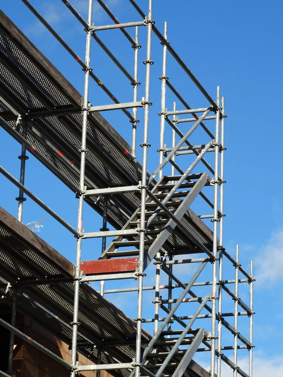 Scaffolding access staircase and metal platforms against a blue sky