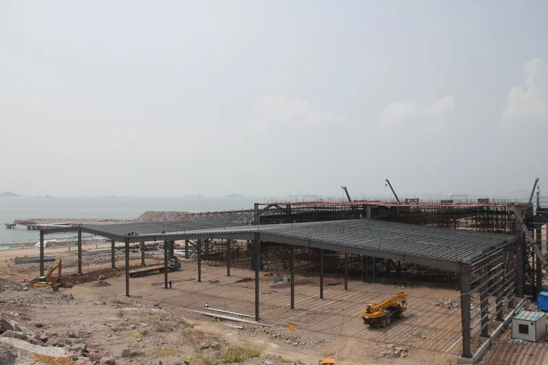 Steel frame warehouse under construction with mobile crane on site, gudang besi