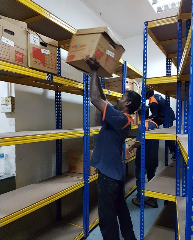 Crew member placing a box onto storage shelving