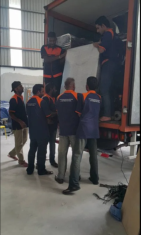 Crew lifting a wrapped item into the back of a lorry, pindah rumah Klang