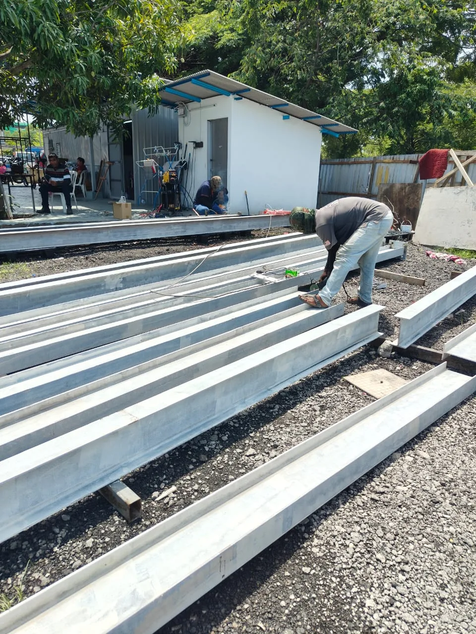 Worker welding steel I-beams in the fabrication yard, fabrikasi besi Klang