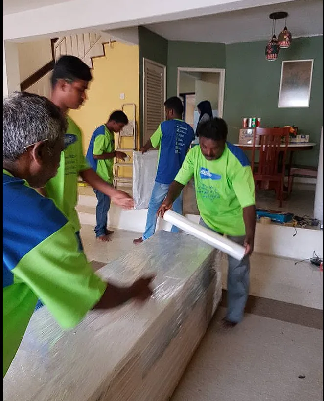 Crew stretch-wrapping a sofa inside a home during a move