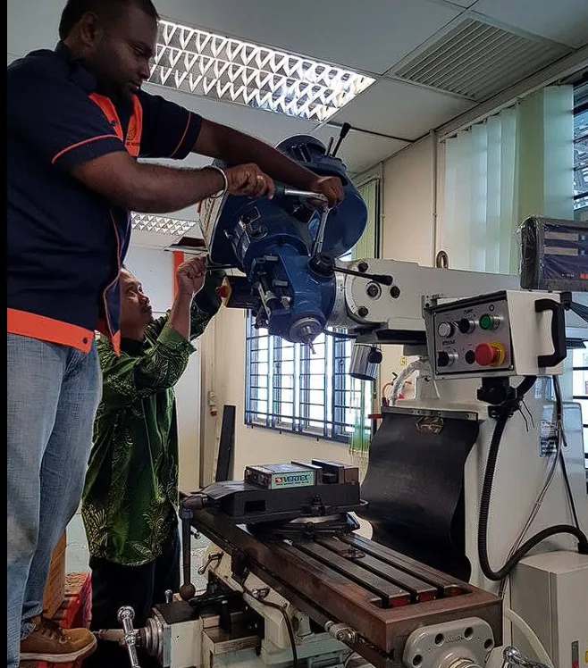 Technicians positioning a milling machine head during installation