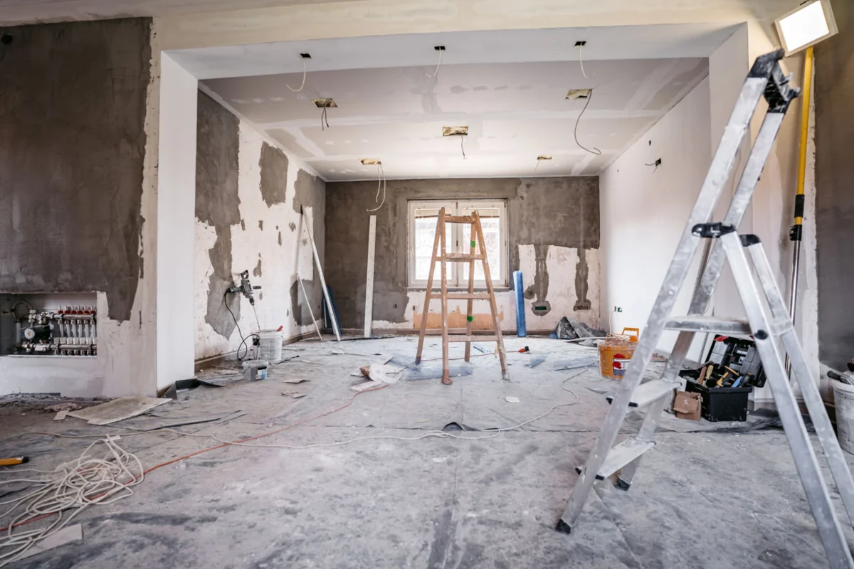 Room under renovation with plasterboard ceiling, unfinished walls and ladders