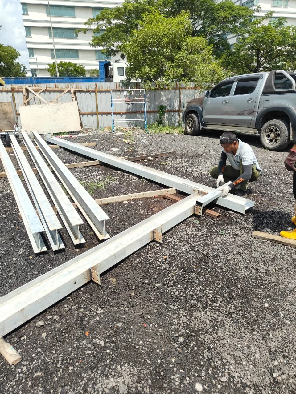 Worker fitting a bracket joint onto a steel frame beam