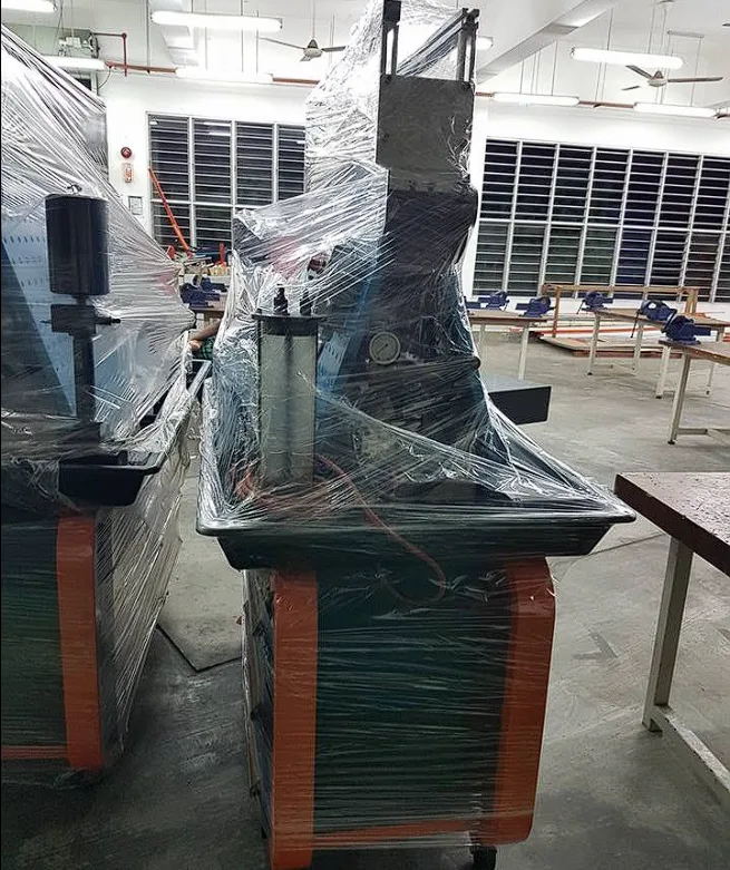 Wrapped press machine ready for relocation beside workbenches
